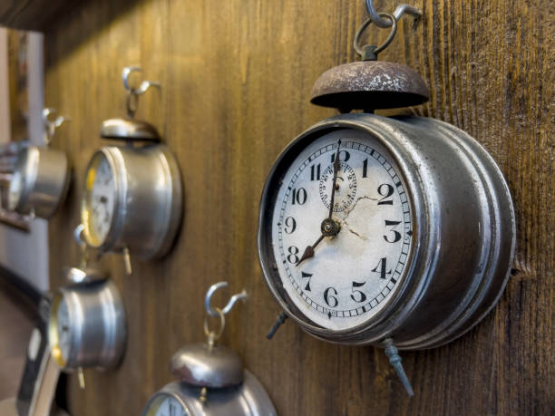 vintage alarm clocks hanged on wooden background stock photo