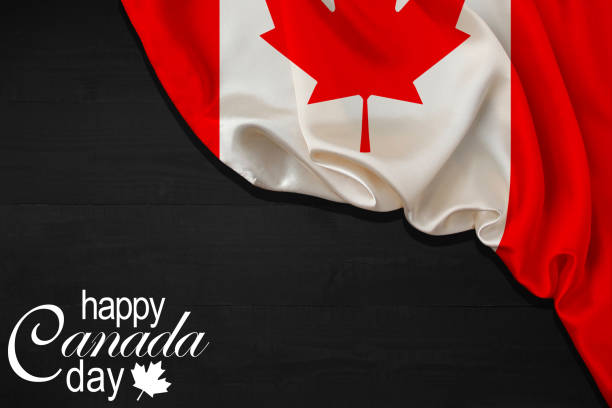 istock Happy Canada Day calligraphy lettering with red maple leaf and a Flag on black wood background. Vector illustration. Paper art style. 1st of July. 1493702283