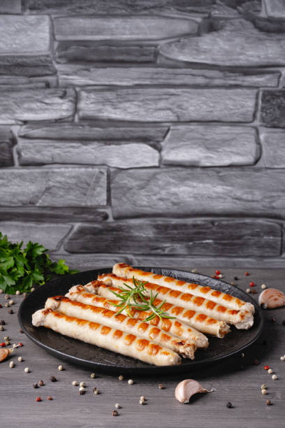 istock Fresh fried chicken sausages in a plate on a gray table. Empty copy space 1493704420