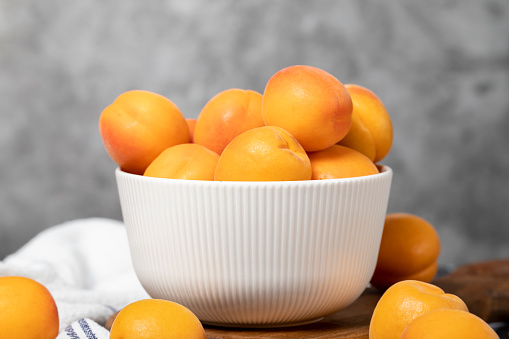 Apricots in bowl. Organic farm products. Tasty apricot on dark background
