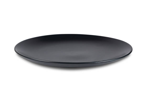istock High angle view of single new black empty ceramic plate isolated on white background. 1493710078
