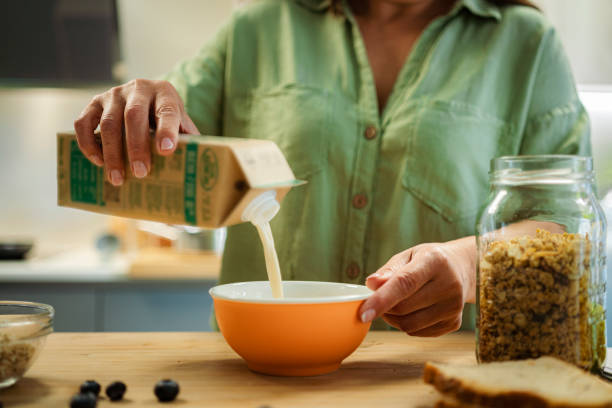 istock Woman pouring soy milk into a bowl for healthy breakfast 1493710135