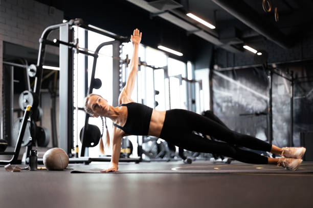 istock Muscular sport woman doing side plank at gym. 1493710208