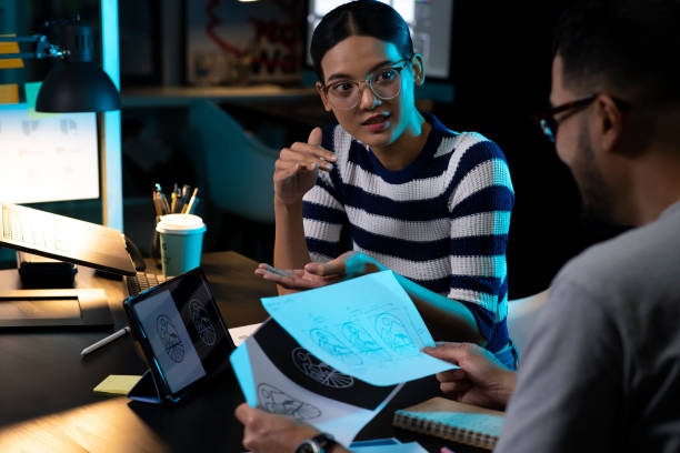 istock Two Asian Graphic designers are discussing and working in the office at night. 1493711548