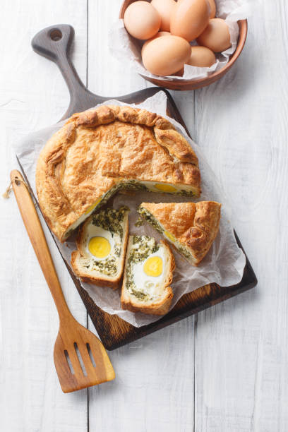 istock Torta Pasqualina traditional Italian savory pie with spinach, chard, ricotta and whole eggs closeup on the wooden board. Vertical top view 1493719023