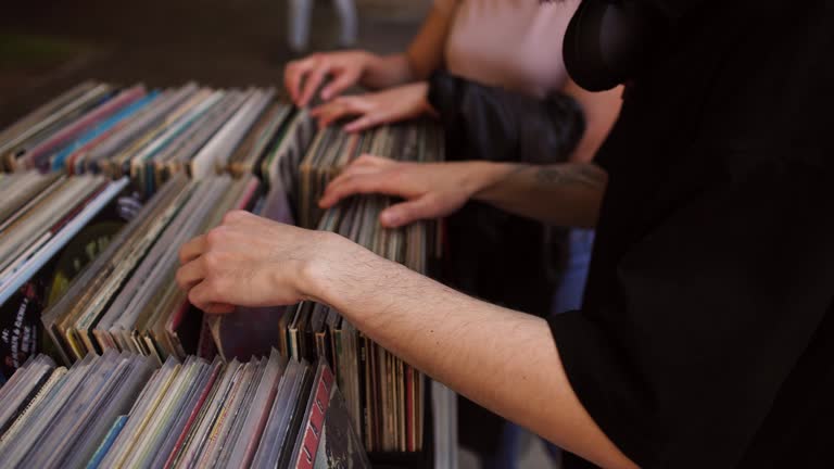 Unrecognizable people searching for a vinyl record at the outdoor record music market