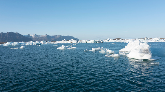 Wide panorama of the Jokulsarlon Glacial lagoon. Mirror reflection of the blue ice icebergs