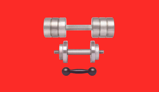 Sports equipment - different weight dumbbells isolated on red background
