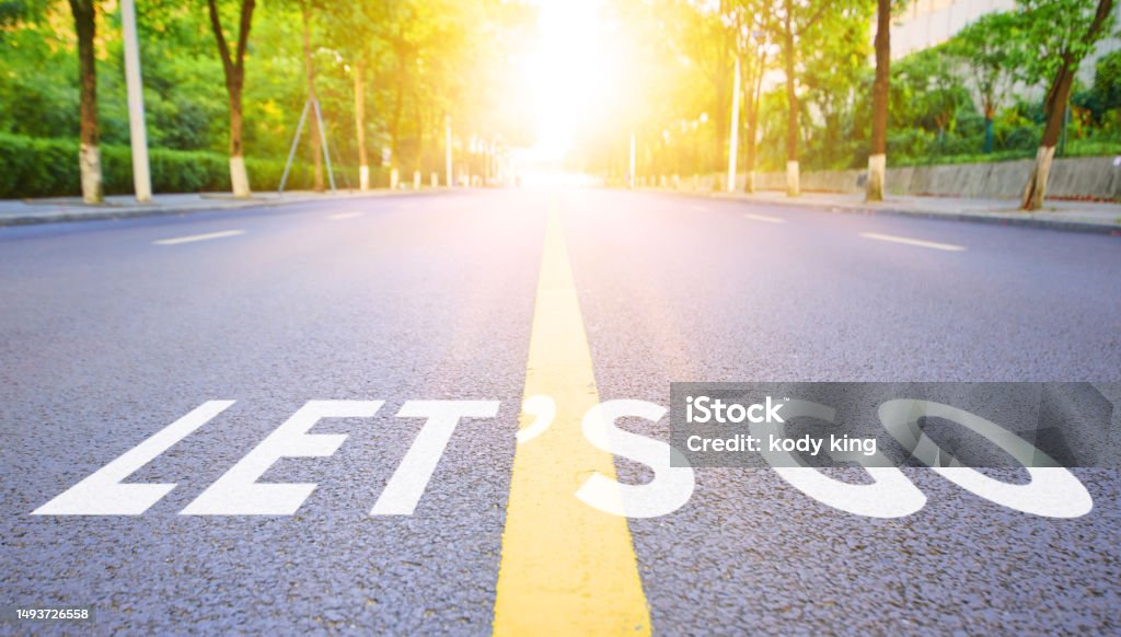 The straight highway surface is marked with LET'S GO Change Stock Photo