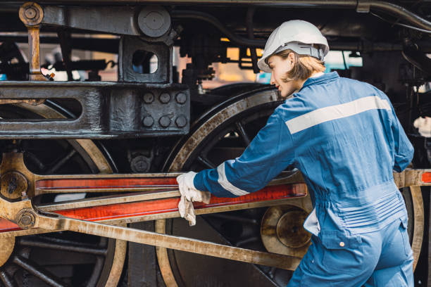 istock Train engineer team working service maintenance old dirty vintage classic steam engine locomotive in train repair workshop at train station. 1493729824