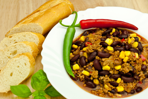 chili con carne with bread on wooden table