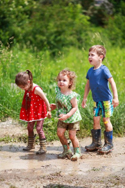istock Children jumping in puddles of mudd 1493734352