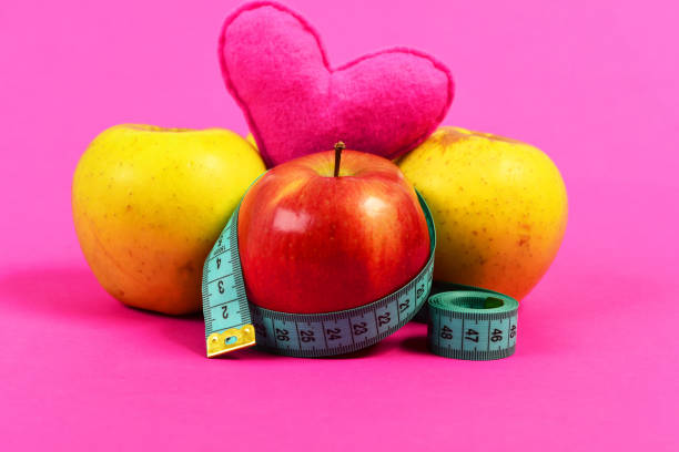 apples wrapped twisted measuring tape isolated on ___ background. Concept of