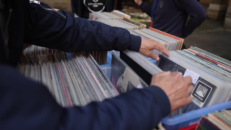 Unrecognizable senior man, browsing through box with vinyl records at the outdoor record market