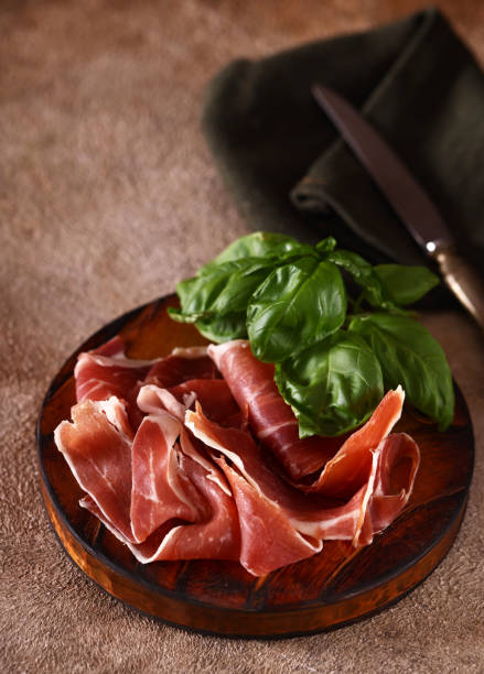 organic parma ham dry cured jamon on a wooden board