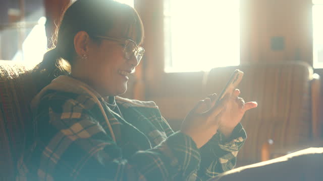 Women using smart phone in wooden house