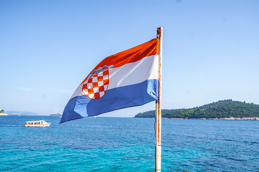 Croatian flag on a windy day by the sea