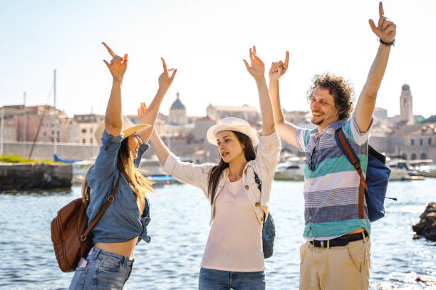 istock Three happy tourists by the see shore 1493741101