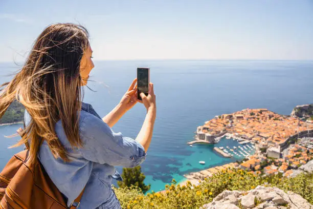 Photo of Woman takes photo of a beautiful costal view