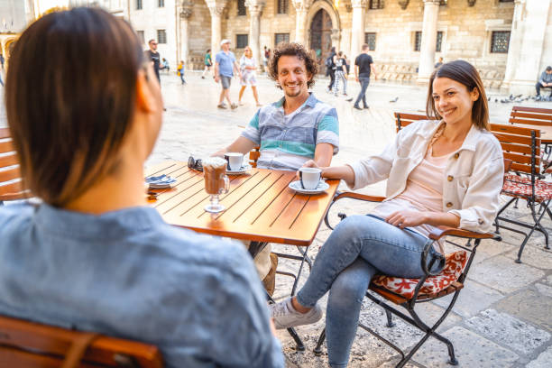 istock Three friends sitting in a coffee shop in town talking and drinking coffee 1493743409