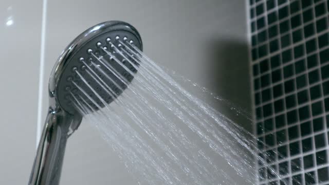 Modern shower discharging water in the bathroom