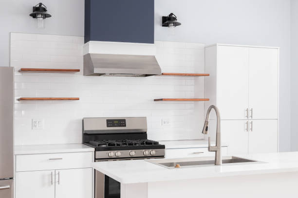 istock A kitchen detail with white cabinets, tiled backsplash, and blue oven hood. 1493744647
