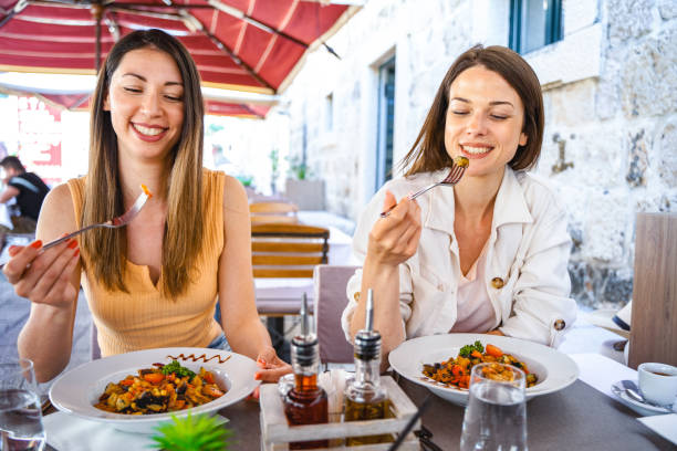 istock Two girls having meal at the restaurant outside 1493746285