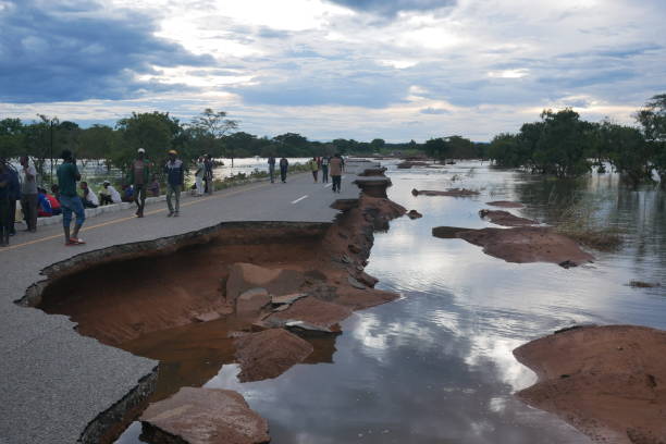Mozambican villagers wait for help at a collapse bridge after Cyclone Freddy stock photo