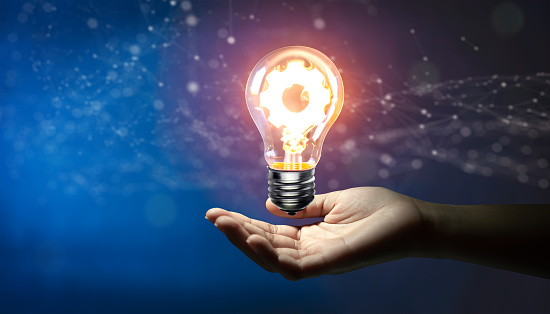 Hand holding Creative light bulb with cog inside and technology background. Innovation business idea knowledge, Planing strategy, and Analysis solution development Concept.