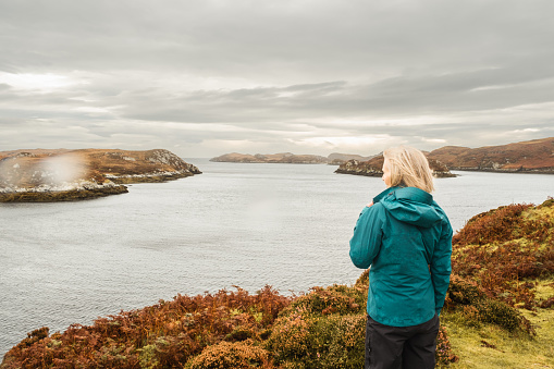 Woman at a harbour on a remote location in the Outer Hebrides of Scotland.