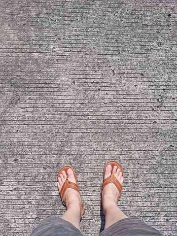 Picture of person stand on concrete pathway in the middle of hot sunny day