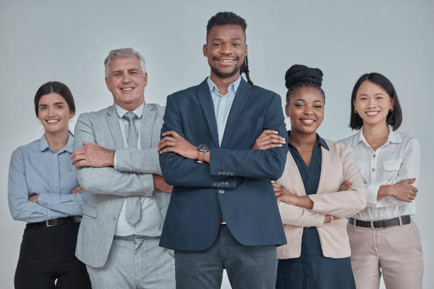 istock Leadership, team and business people with crossed arms in a studio with confidence, unity and teamwork. Collaboration, corporate and portrait of a group of employees standing by a gray background. 1493763610