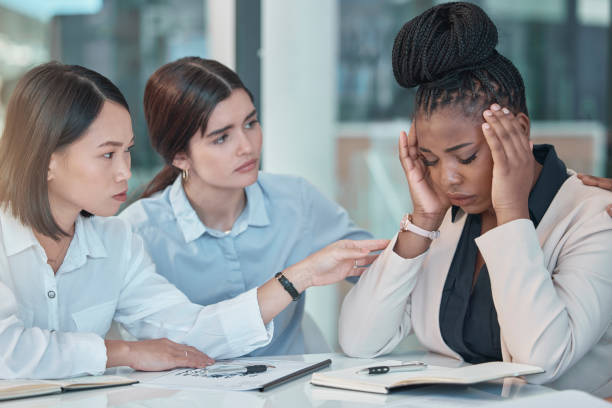 istock Headache, stress and support with a business black woman suffering from burnout while colleagues console her. Anxiety, mental health and depression with a female employee group comforting a coworker 1493763638