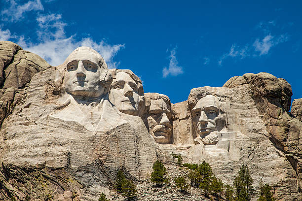 Mount Rushmore underneath a blue sky Close up view of Mount Rushmore with a blue sky mt rushmore national monument stock pictures, royalty-free photos & images