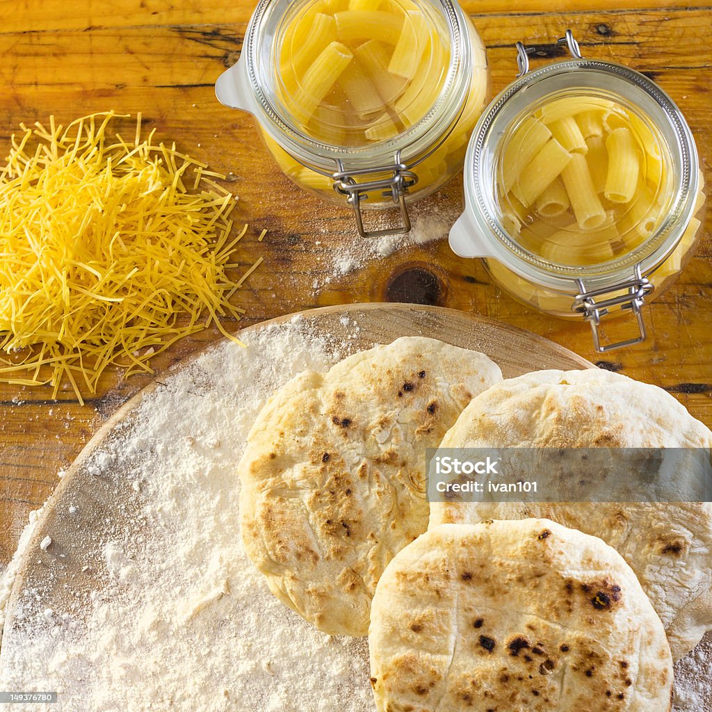 Homemade bread High angle view of bread, flour and pasta on wood. Baked Stock Photo