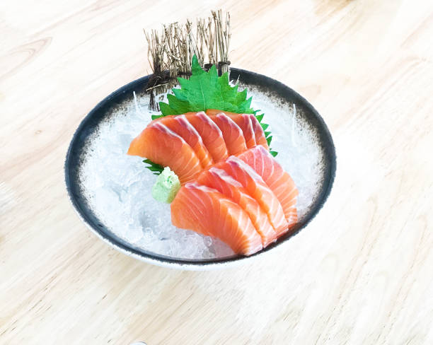 istock Salmon sashimi cutting fresh and raw pieces served on ice in a bowl. 1493768885