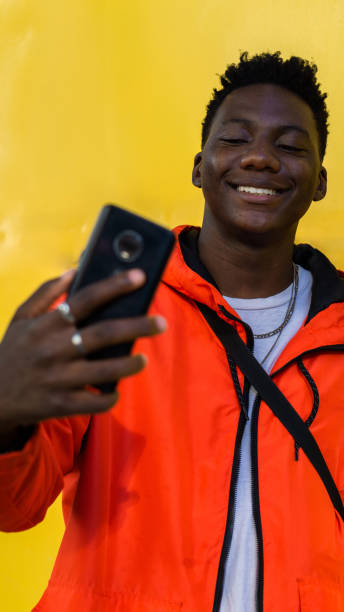 istock Young handsome African man taking a selfie on a yellow background. 1493770251
