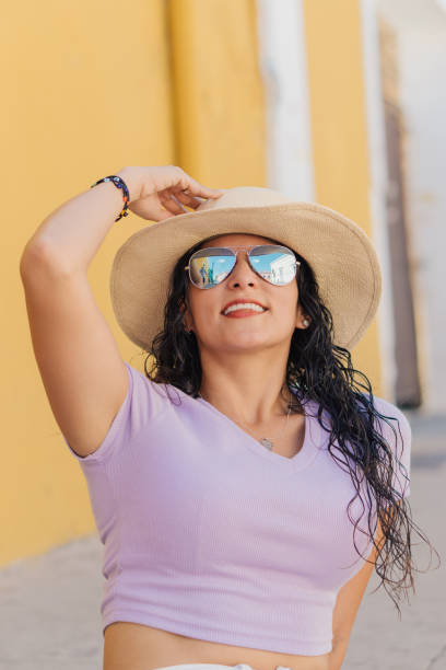 istock Latin woman smiling and holding her hat. 1493770642