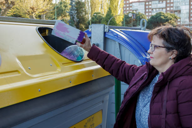 istock woman throwing plastics in a specific yellow container for recycling and environmental care 1493779714