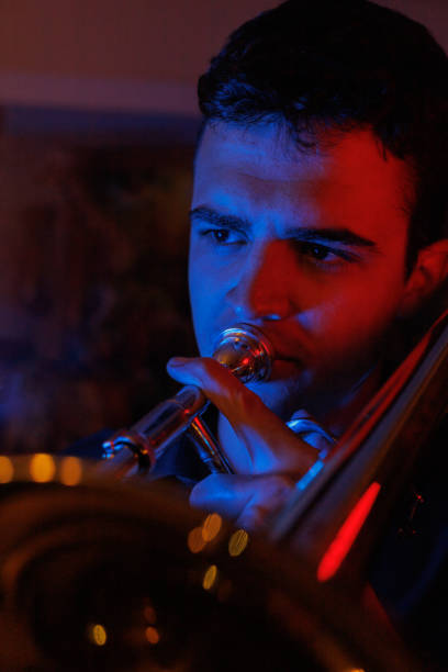 istock boy playing jazz trombone with red and blue lights 1493779719