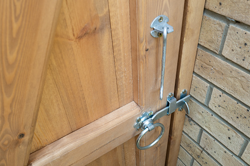 Shallow focus of a newly installed wooden garden gate. Showing the metal latch and ring type handle.