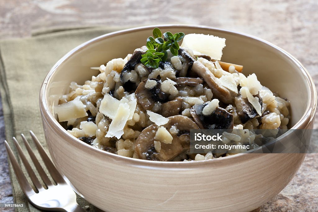 Mushroom Risotto Bowl of mushroom risotto, garnished with thyme and parmesan. Risotto Stock Photo