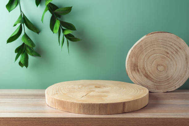istock Empty wooden podium log for presentation on table over green background. Cosmetic mock up for design and product display 1493789313