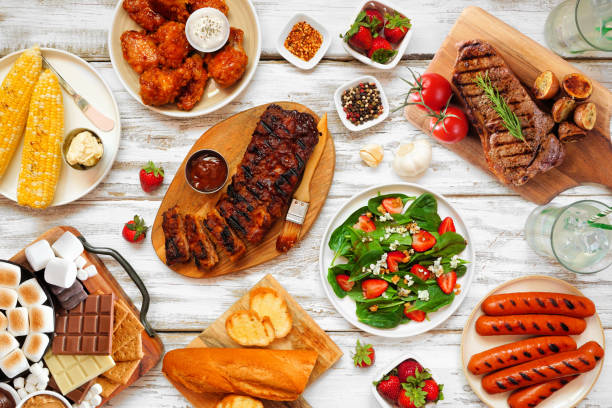 istock Summer BBQ food table scene over a white wood background 1493790614