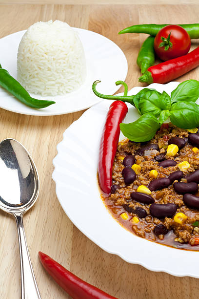 chili con carne with rice on wooden table