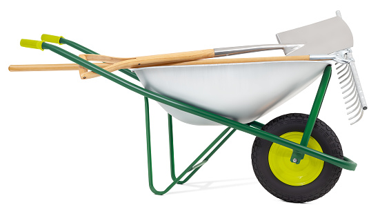 Wheelbarrow with rake and spade, isolated on white background with clipping path. Gardening equipment tool for vegetable garden work, farming or planting. Spring concept, banner for online shopping