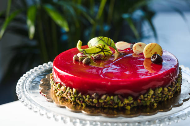 Red mirror half glazed cake with pistachio and chocolate on top