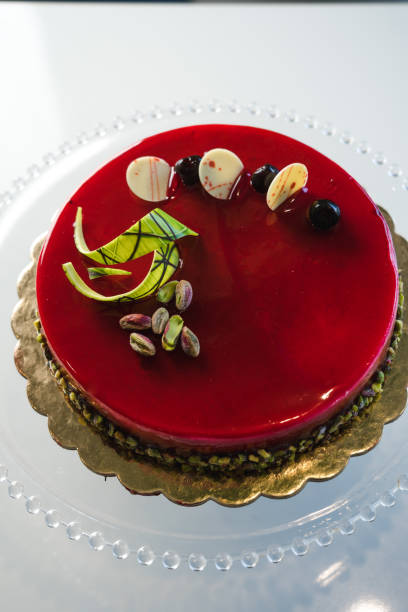 istock Red mirror half glazed cake with pistachio and chocolate on top 1493801150