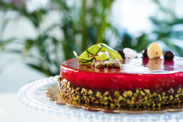 istock Red mirror half glazed cake with pistachio and chocolate on top 1493801281