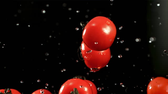 Tomatoes fly up with water drops. Filmed is slow motion 1000 fps.